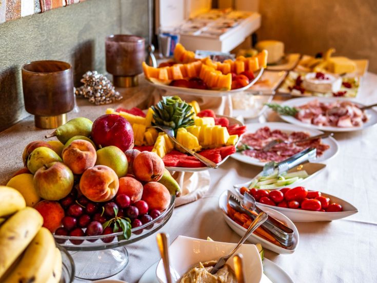 Un assortimento di frutta fresca e salumi in un ambiente semplice e accogliente.