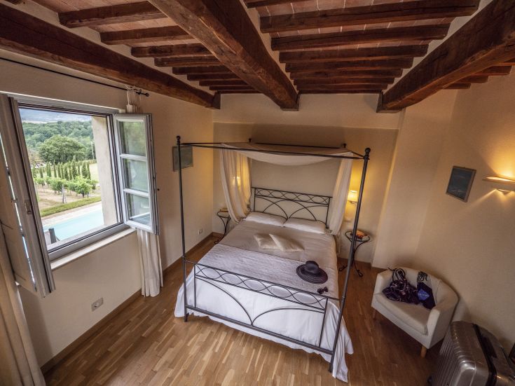 Camera accogliente con letto a baldacchino e panorama sui vigneti, ideale per un soggiorno tranquillo.