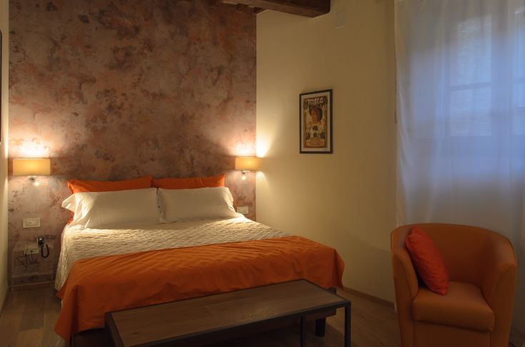 Simple bedroom with a double bed and minimalist decor, located in a serene environment.