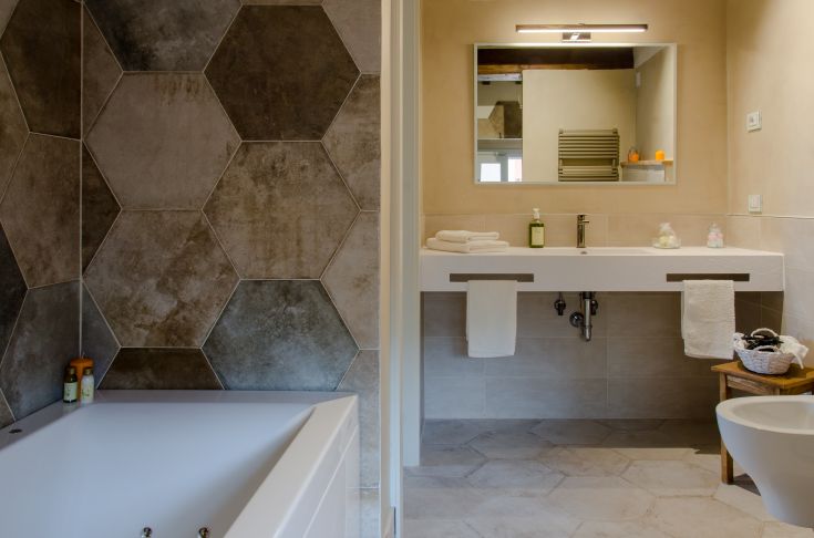 A modern bathroom with hexagonal walls and a contemporary sink. A calm and functional space for personal care.