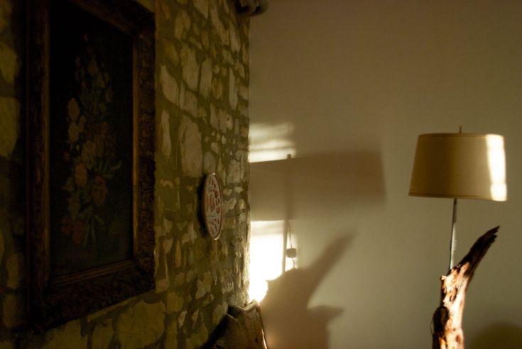 Gemütliches Innere eines Hauses mit Steinwänden und einfachen Möbeln, die eine einladende Atmosphäre schaffen.