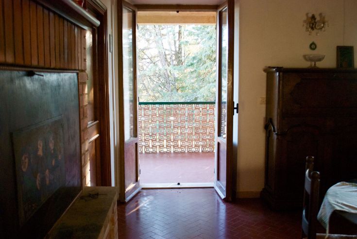 Innenansicht eines Agriturismo mit einer gemütlichen Atmosphäre und Blick auf einen Balkon, umgeben von Natur.