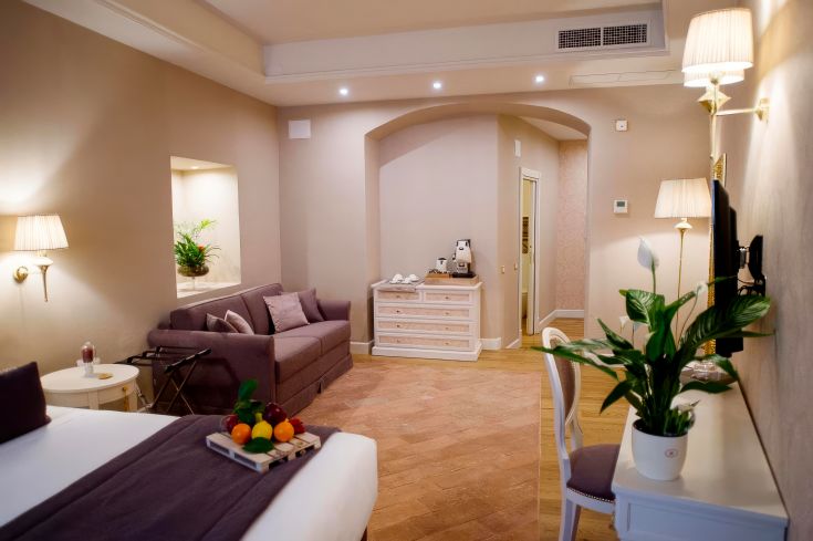 Suite Junior confortable avec des meubles douillets et un espace détente, idéale pour une escapade romantique.