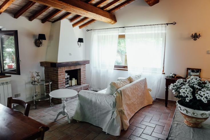 A bright living room with a fireplace, simply and functionally furnished, creating a cozy atmosphere.