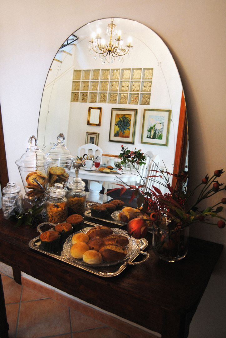 A tranquil breakfast table set with fresh food and sweets, featuring a simple mirror on the wall.