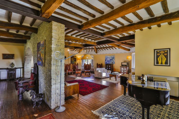 Un salon confortable avec des poutres en bois apparentes, aménagé de manière équilibrée pour le confort.