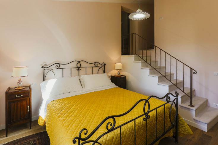 Chambre bien meublée avec un lit double et des détails simples, entourée d'un environnement verdoyant et paisible.