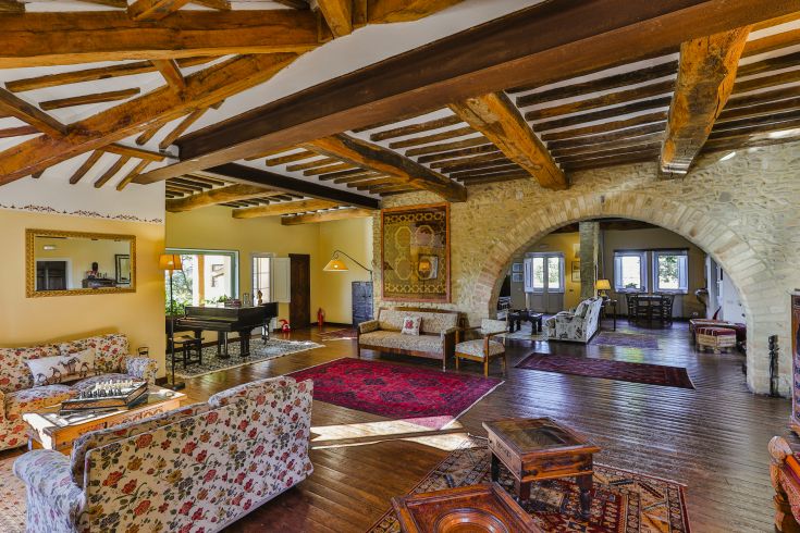 Intérieur simple et confortable avec des poutres apparentes et des meubles typiques, idéal pour se détendre à la campagne.