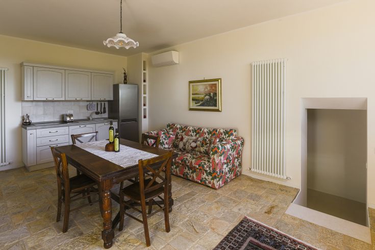 Cuisine et séjour spacieux avec des meubles en bois et des détails floraux, créant une atmosphère lumineuse et confortable.