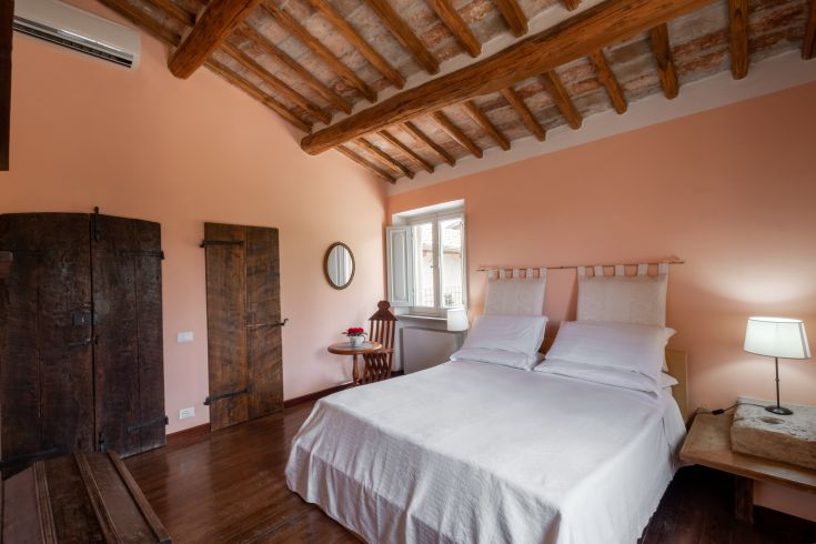 Chambre simple avec poutres apparentes et meubles traditionnels, parfaite pour des moments de détente.