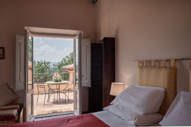 Une pièce bien éclairée avec accès à une terrasse, entourée de la végétation typique de l'Ombrie, idéale pour la détente.