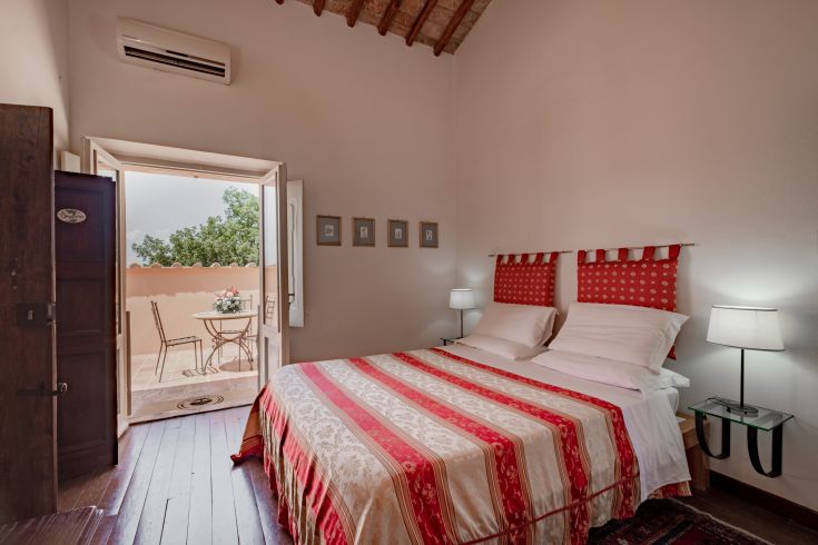 Chambre simple avec accès à un patio extérieur, idéale pour un séjour paisible.