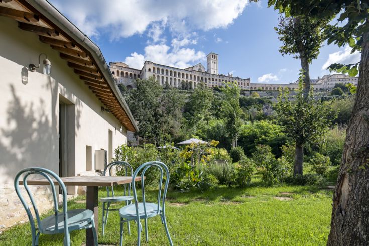Un tranquillo angolo del Borgo Antichi Orti, con panorama su Assisi e un giardino ben curato.