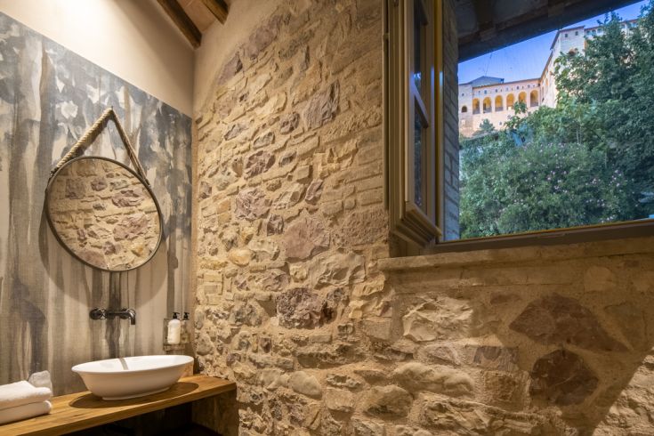 Un bagno semplice e confortevole con elementi in pietra naturale e tocchi contemporanei, ideale per il relax.