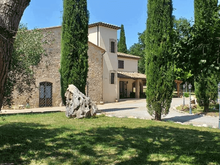 Ein Landhaus inmitten der Natur, umgeben von Bäumen und natürlichen Räumen, perfekt für entspannende Momente in Umbrien.