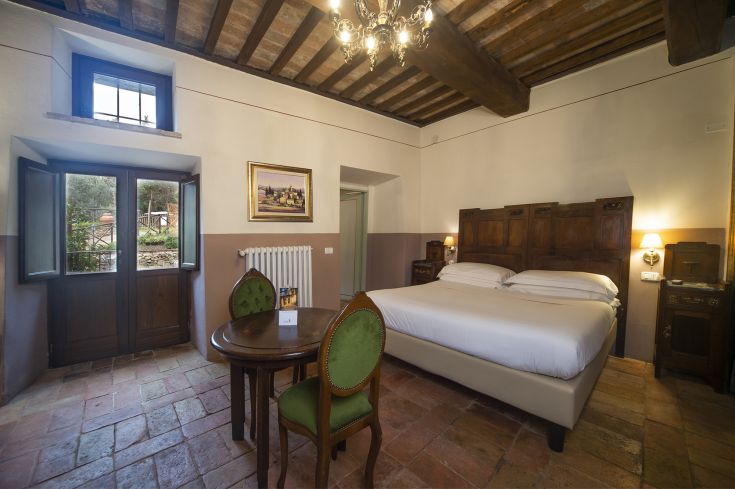 Comfortable room with rustic elements, ideal for a relaxing stay. Scene of a green garden.