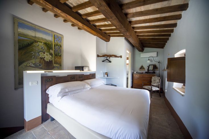 Comfortable room with a double bed and wooden furnishings. The atmosphere is relaxing and welcoming.