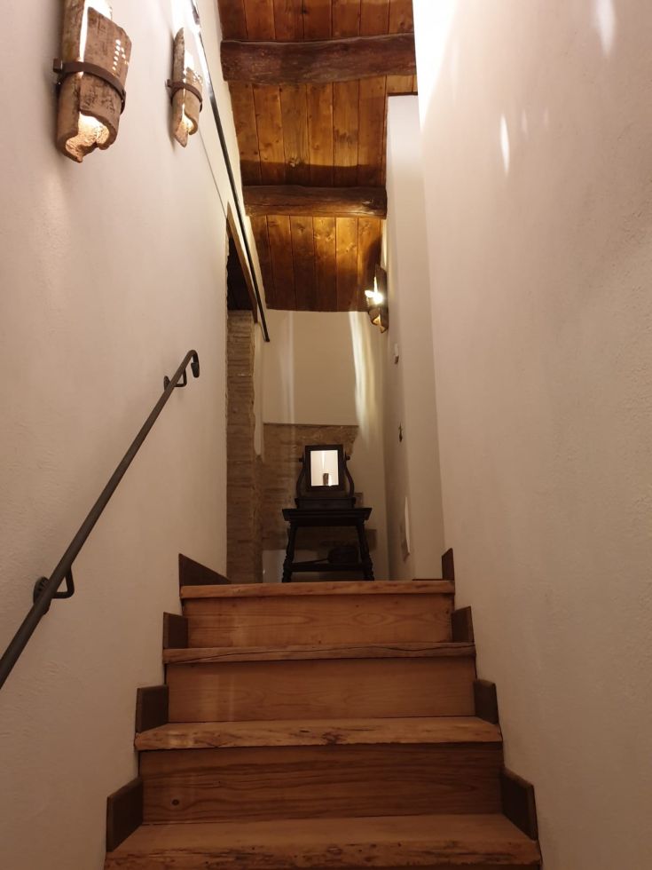 Scale in legno che portano a un ambiente semplice e confortevole, con un'illuminazione delicata.