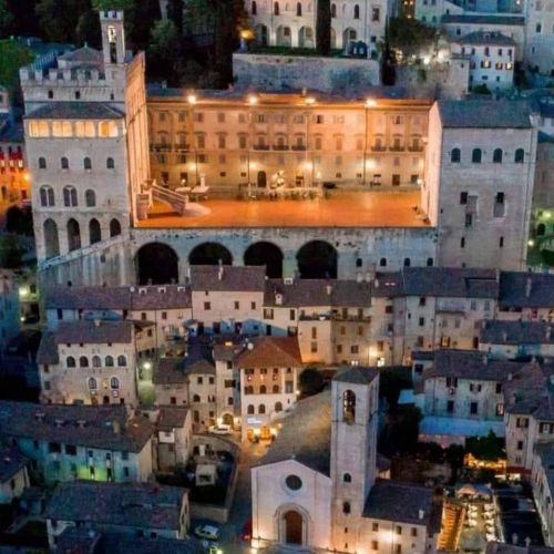 Night scene of a square featuring historic buildings and warm lighting.