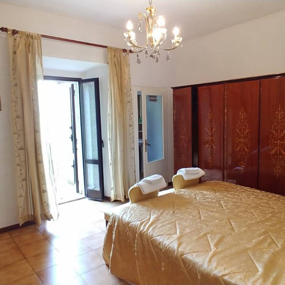 Well-lit room featuring a double bed and a simple designed wardrobe.