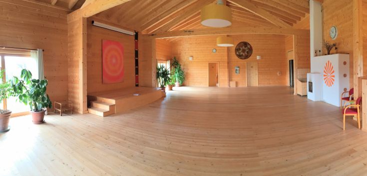 A spacious event area with natural light and decorative plants, perfect for meetings and retreats.