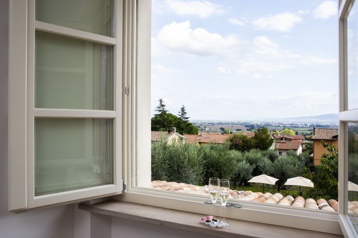 A view of an Umbrian landscape with champagne glasses on the windowsill.