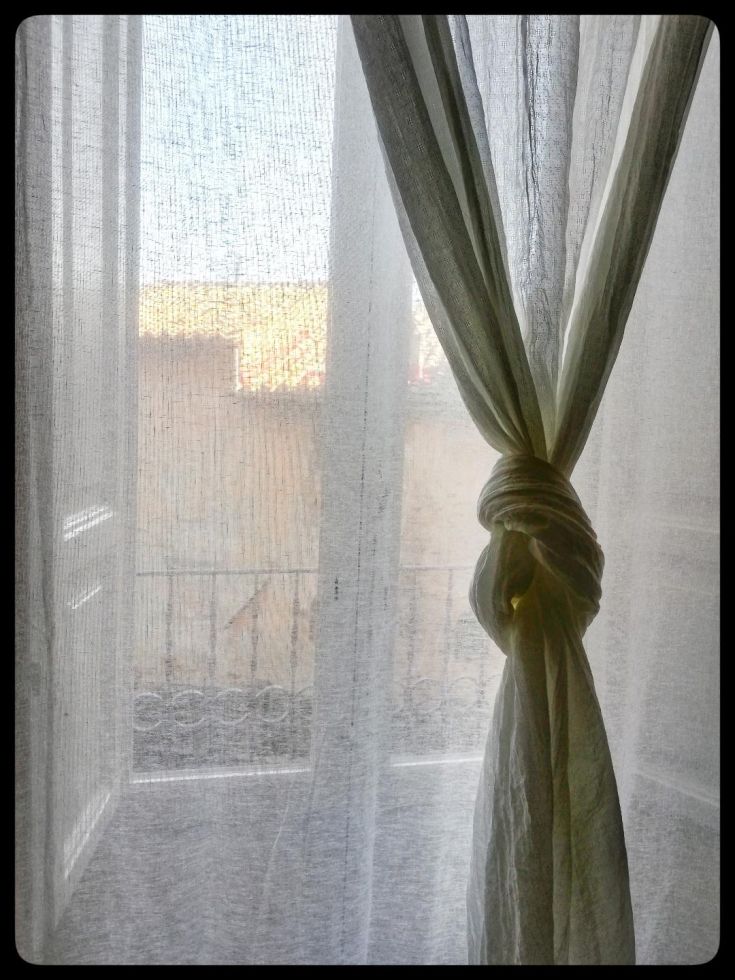 Tende leggere che adornano un balcone, contribuendo a un ambiente luminoso e accogliente.