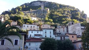 A view of an ancient mountain village with warm-toned houses and visible historical remnants.