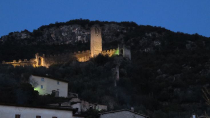 A lit building on a hill, visible at twilight.
