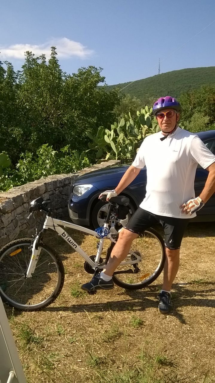 A male cyclist on his bike, ready for a ride in a beautiful natural landscape.