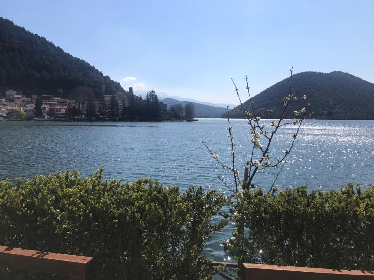 A lake surrounded by hills, with a clear and serene sky reflected in the water.