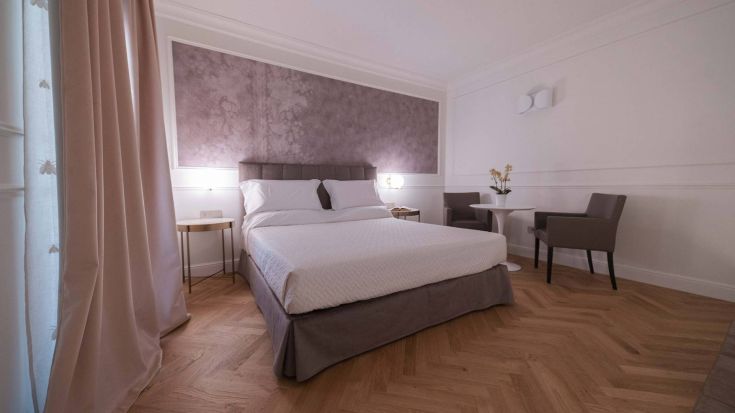 Camera luminosa con letto matrimoniale, arredamento semplice e accogliente, perfetta per un soggiorno rilassante.