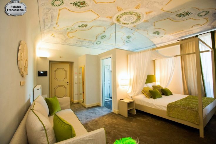 Camera con affreschi del ‘700 e mobili d'epoca. Un ambiente che riflette storia e cultura.