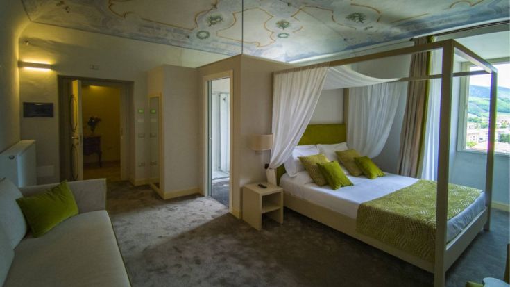 Camera ben arredata con letto a baldacchino e mobili d'epoca. Un ambiente rilassante adatto al soggiorno.