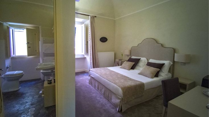 Camera essenziale dotata di bagno privato, ideale per un soggiorno tranquillo in un edificio storico.