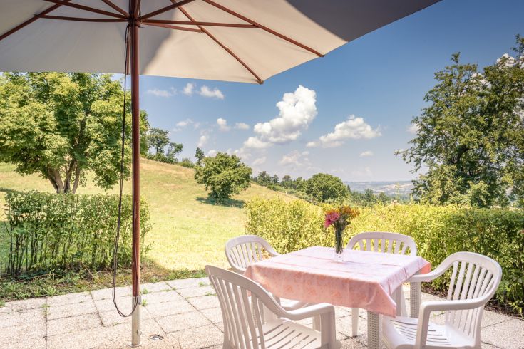 Area esterna con tavolo e sedie, immersa in un paesaggio verde nella campagna umbra.