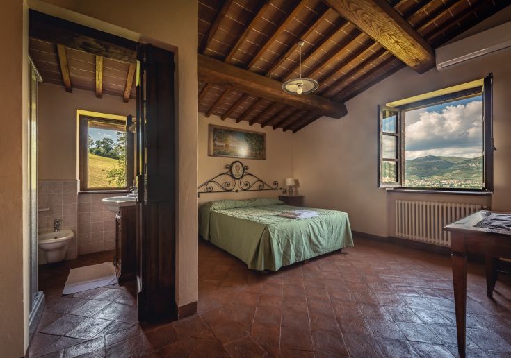 Camera accogliente con panorama rilassante, arredata in stile rustico semplice. Perfetta per un soggiorno sereno.