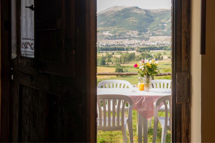 Tavolo decorato con fiori freschi, accompagnato da un panorama sulle colline circostanti.
