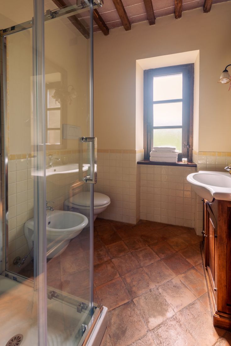 Un bagno in stile rustico con doccia, semplice e accogliente. Luce naturale per un'atmosfera rilassante.