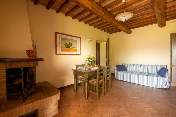 Soggiorno accogliente con camino e mobili in legno, ideale per momenti di relax in agriturismo.