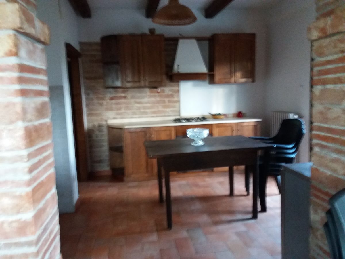 A spacious and welcoming kitchen featuring a wooden table and dark wood cabinets.
