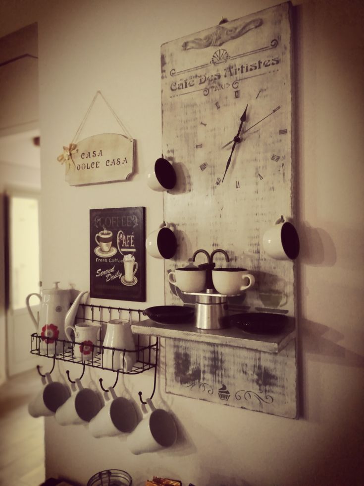 Una cucina semplice con un orologio d'epoca e tazze appese, perfetta per trascorrere momenti insieme.