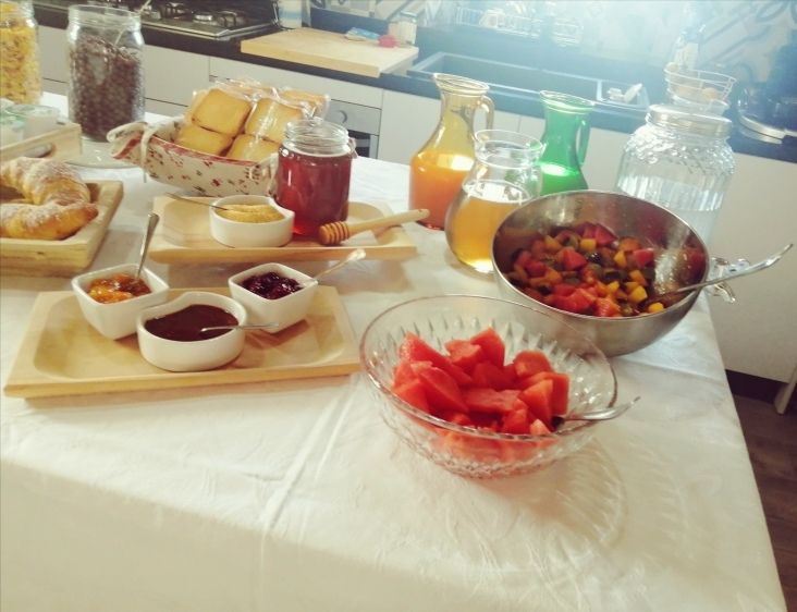 Colazione variegata con frutta fresca e marmellate fatte in casa all'interno di un accogliente B&B.