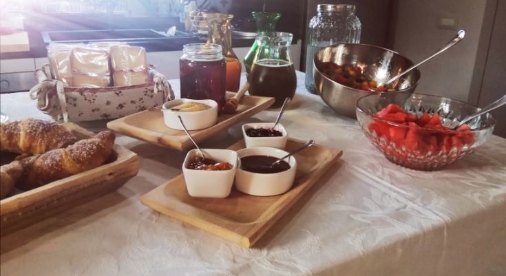 Colazione con dolci, marmellate, frutta fresca di stagione in un ambiente accogliente.