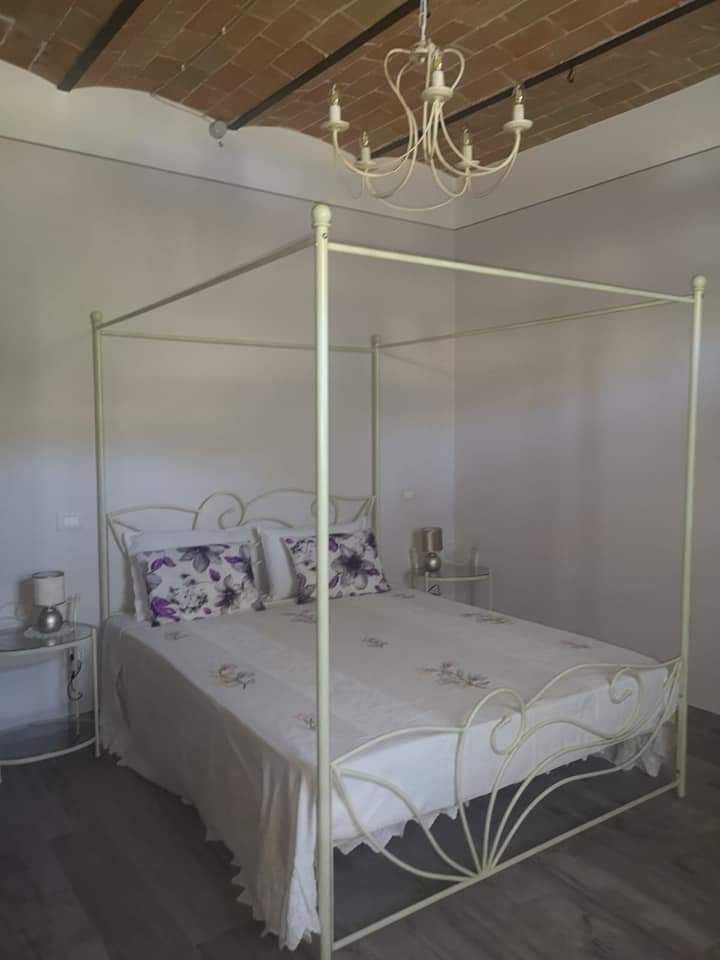 Camera matrimoniale con letto a baldacchino e dettagli decorativi ispirati alla natura.