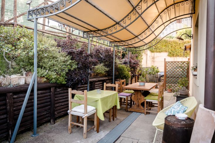 Spazio esterno del B&B con tavoli e piante, ideale per colazioni all'aperto e momenti di relax.