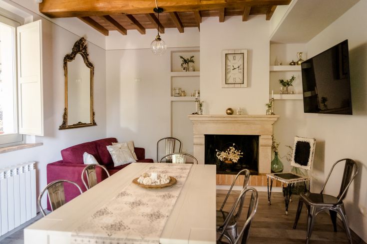 Spazio pranzo di un B&B con caminetto, arredamento semplice e alcuni dettagli curati.