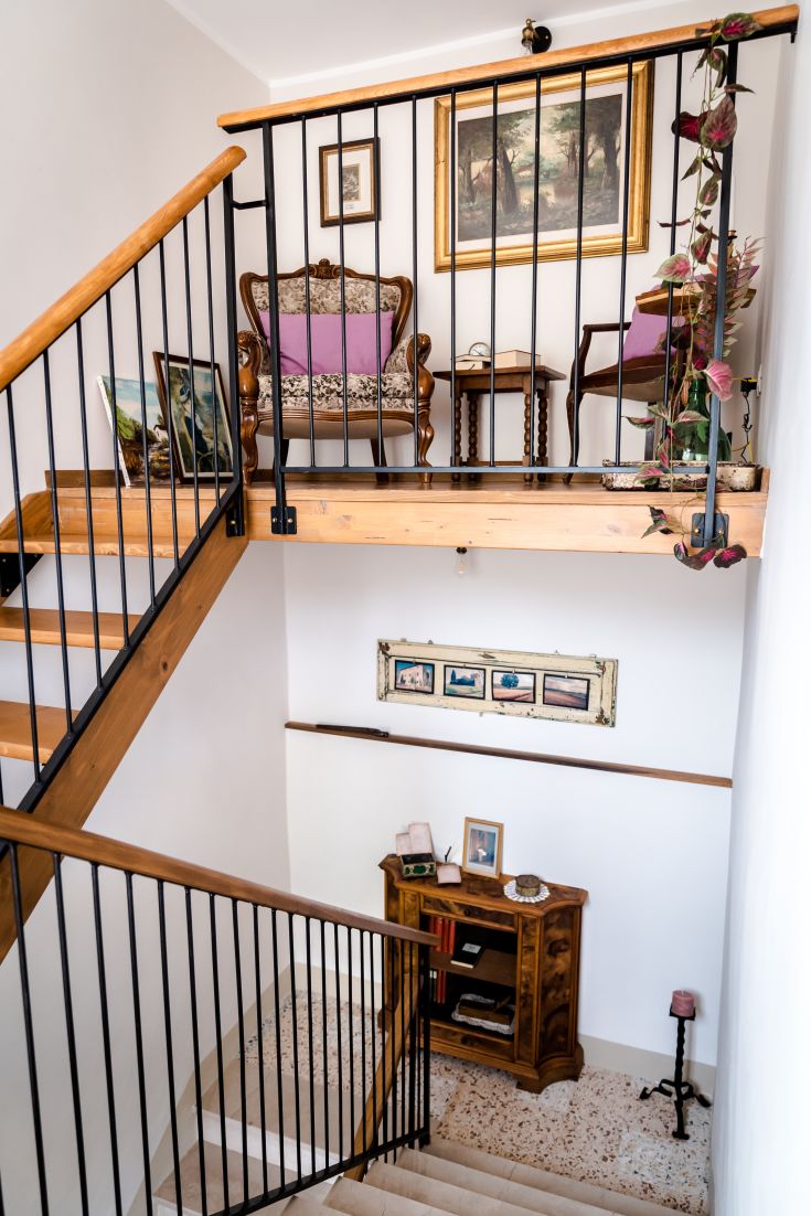 Scale e loggia di un accogliente B&B, arredato in modo semplice con elementi decorativi e piante.