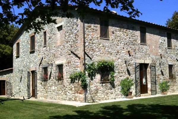 Un casale in pietra con un giardino ben curato, perfetto per una vacanza tranquilla nella campagna.