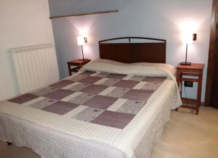 Interior of a bed and breakfast room with simple beds and lamps, creating a cozy atmosphere.